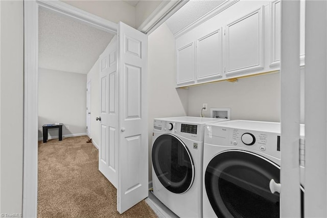 clothes washing area featuring baseboards, cabinet space, a textured ceiling, washing machine and dryer, and light colored carpet