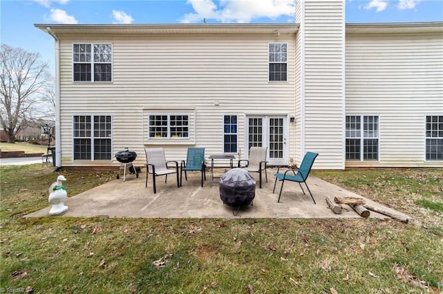 back of property with a patio area, a lawn, and a chimney