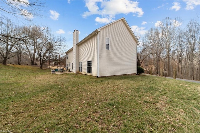 view of property exterior featuring a lawn and a chimney