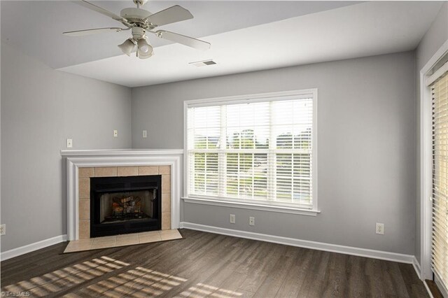 unfurnished living room featuring ceiling fan, wood-type flooring, and a tile fireplace