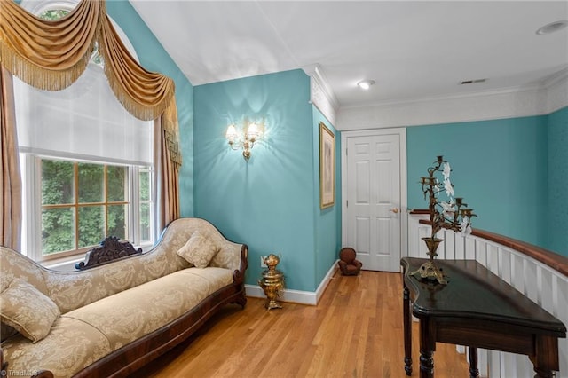 sitting room featuring light hardwood / wood-style floors and crown molding