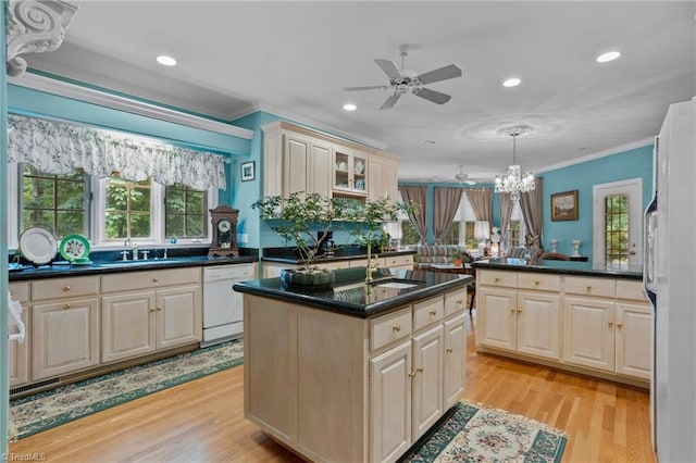 kitchen featuring an island with sink, ceiling fan with notable chandelier, light hardwood / wood-style floors, and white appliances