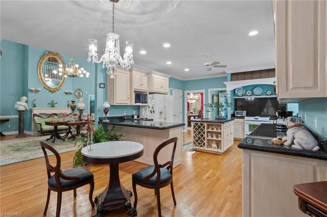 dining room featuring ceiling fan with notable chandelier, light wood-type flooring, and ornamental molding