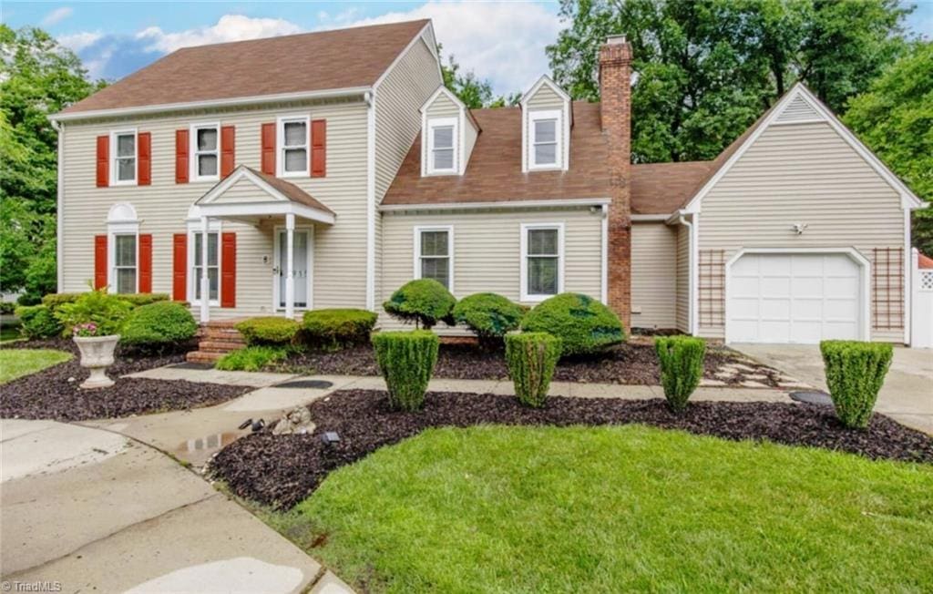 1915 New Garden Rd, Greensboro, NC 27410 - colonial inspired home featuring a garage, a chimney, driveway, and a front lawn