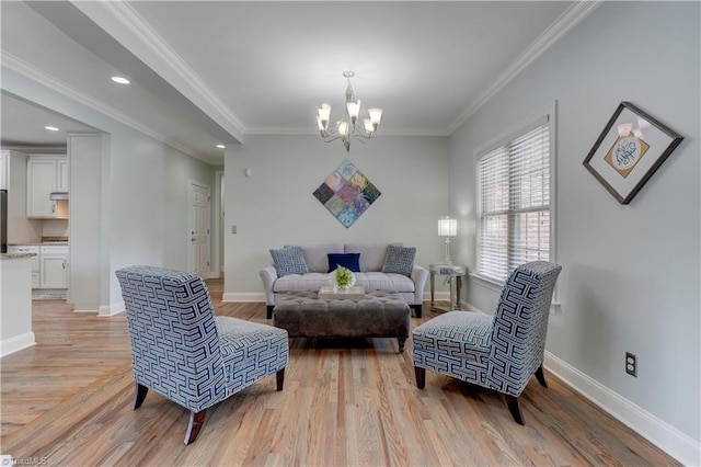 living area with light wood-style floors, a notable chandelier, ornamental molding, and baseboards