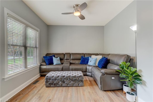 living room featuring visible vents, ceiling fan, baseboards, and wood finished floors