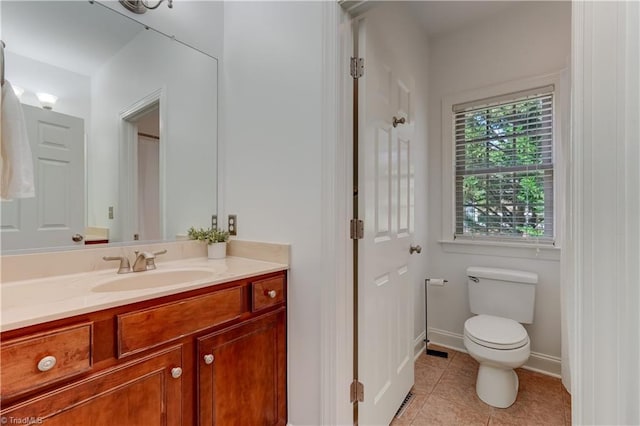 bathroom featuring toilet, vanity, baseboards, and tile patterned flooring