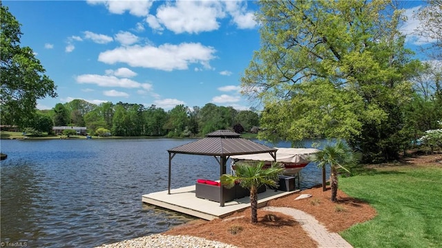 dock area with a water view, a gazebo, and a lawn