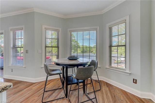 dining area with light wood-style flooring, baseboards, and ornamental molding