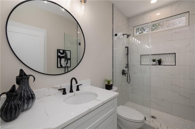 bathroom featuring walk in shower, toilet, and vanity