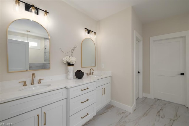 full bathroom with marble look tile flooring, double vanity, baseboards, and a shower