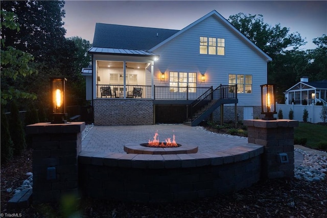 back of property featuring a fire pit, stairway, a standing seam roof, and a patio area