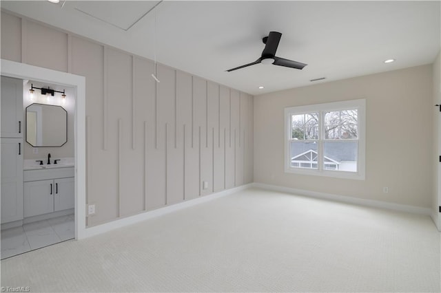unfurnished bedroom with a sink, light colored carpet, baseboards, connected bathroom, and recessed lighting