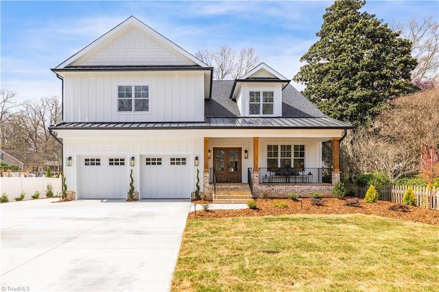 modern farmhouse style home featuring concrete driveway, a standing seam roof, a porch, and board and batten siding