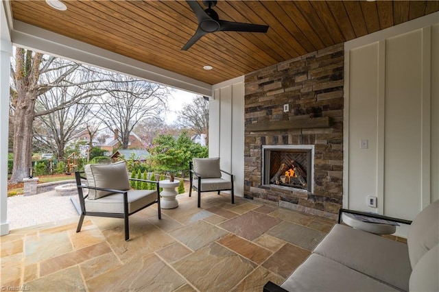 view of patio featuring an outdoor stone fireplace and ceiling fan