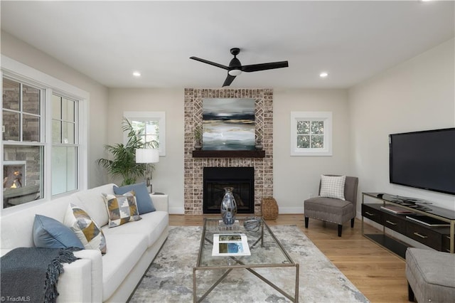 living room featuring a fireplace, ceiling fan, wood finished floors, recessed lighting, and baseboards