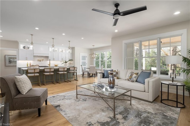 living area featuring light wood finished floors, recessed lighting, and a ceiling fan