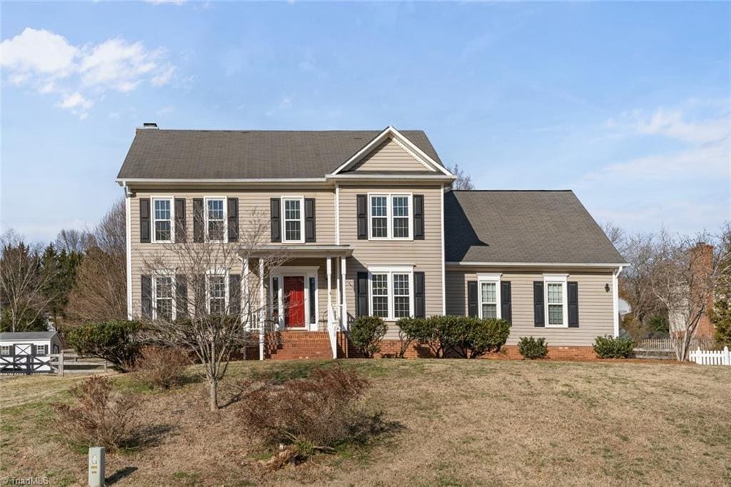 colonial inspired home with a front lawn