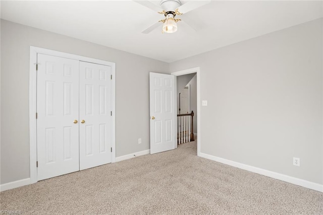 unfurnished bedroom with ceiling fan, light colored carpet, and a closet