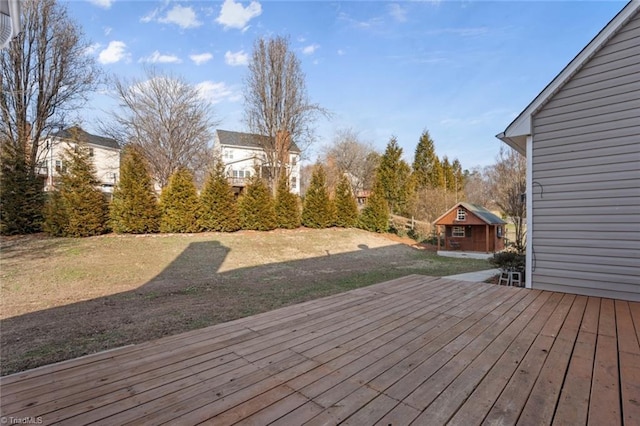 wooden terrace featuring an outdoor structure and a yard