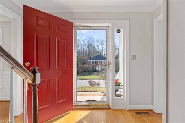 foyer entrance featuring crown molding and light hardwood / wood-style flooring