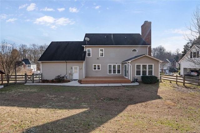 back of house with a wooden deck and a lawn