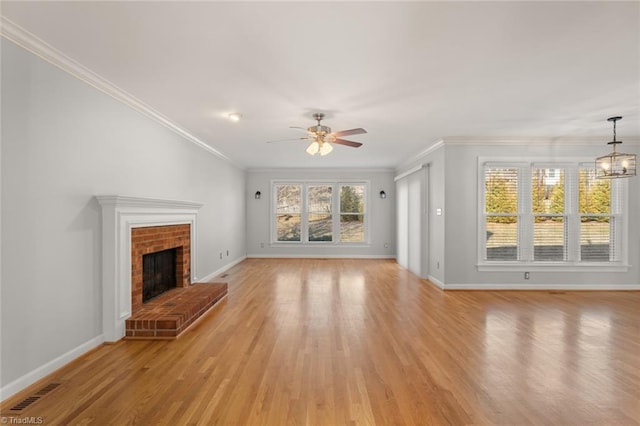 unfurnished living room featuring crown molding, a brick fireplace, and light hardwood / wood-style floors