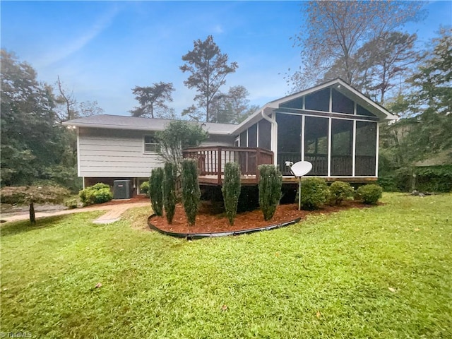 rear view of property with a lawn, a wooden deck, a sunroom, and central air condition unit