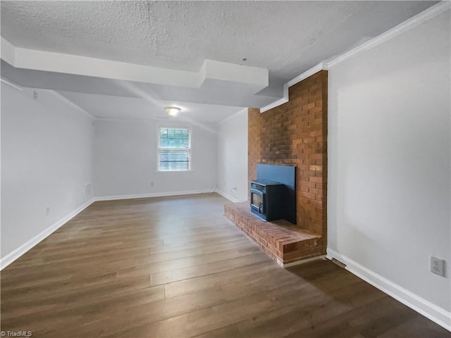 unfurnished living room featuring a textured ceiling, dark hardwood / wood-style floors, lofted ceiling, a fireplace, and crown molding