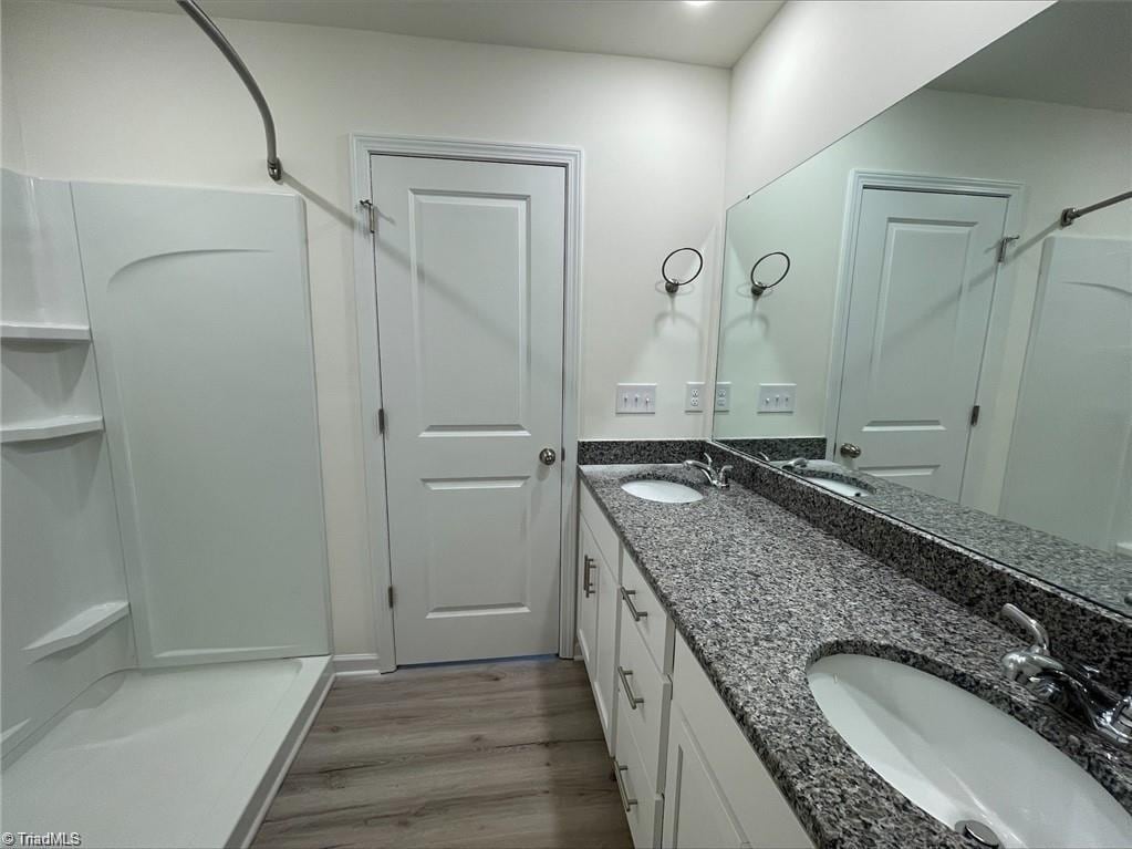 bathroom featuring double vanity and wood-type flooring