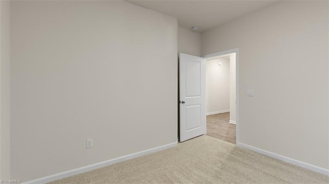 unfurnished room featuring light colored carpet