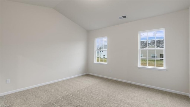 spare room featuring carpet floors and lofted ceiling