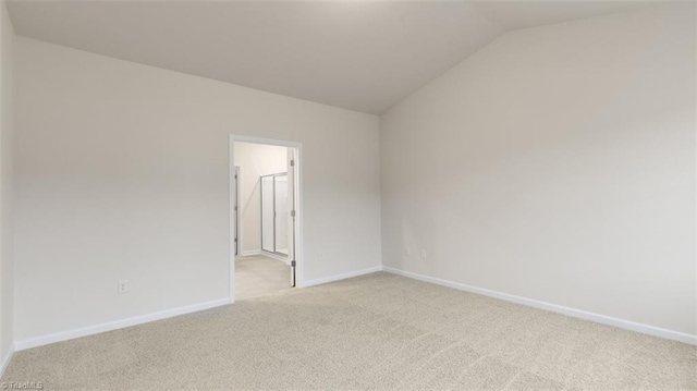 unfurnished room with light carpet and vaulted ceiling