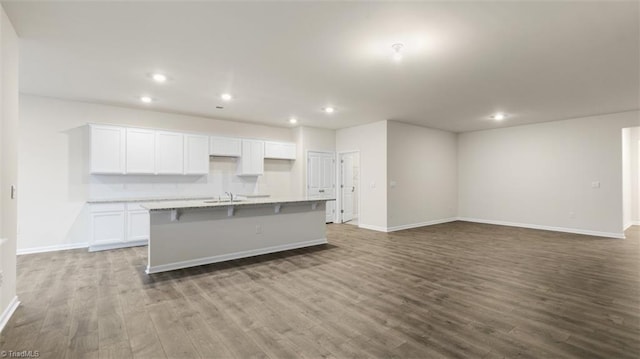 kitchen with a center island with sink, light hardwood / wood-style flooring, white cabinets, and sink