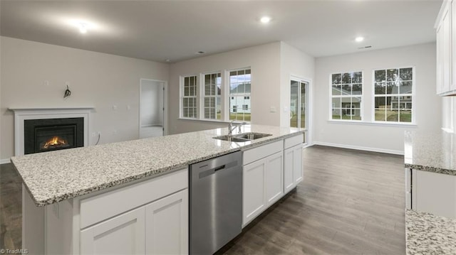 kitchen with sink, white cabinetry, stainless steel dishwasher, and a kitchen island with sink