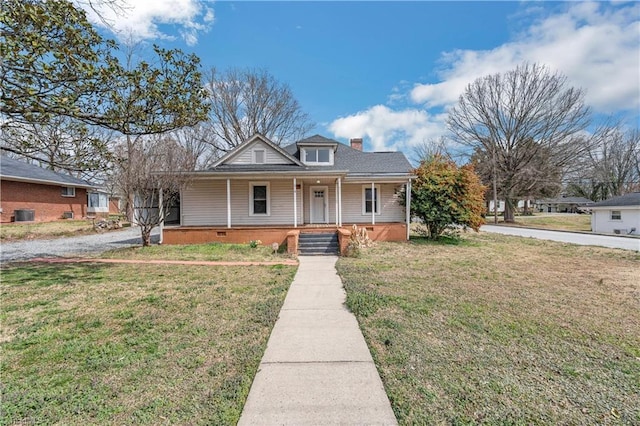 bungalow-style house featuring a front yard, a chimney, covered porch, and crawl space