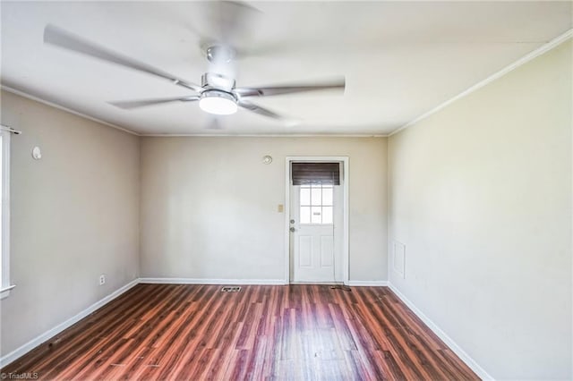 empty room featuring baseboards, wood finished floors, a ceiling fan, and crown molding