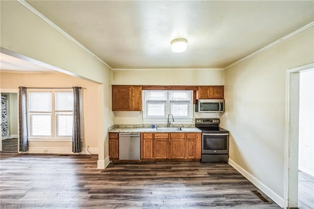 kitchen featuring visible vents, dark wood-type flooring, appliances with stainless steel finishes, brown cabinetry, and a sink