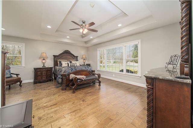 bedroom with a raised ceiling, wood-type flooring, baseboards, ceiling fan, and recessed lighting