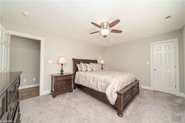 bedroom featuring light carpet, baseboards, and a ceiling fan