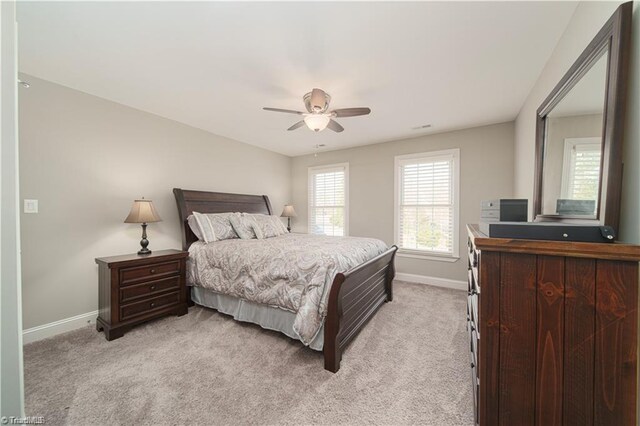 bedroom featuring baseboards, light carpet, and a ceiling fan