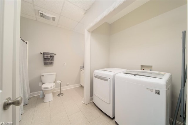 laundry room featuring separate washer and dryer and baseboards