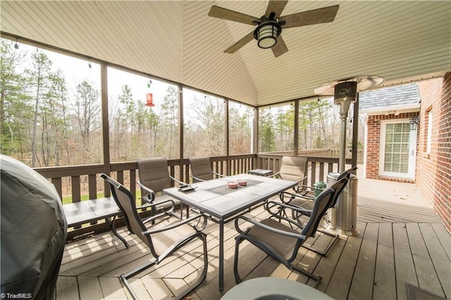 sunroom featuring outdoor dining area, ceiling fan, and healthy amount of natural light