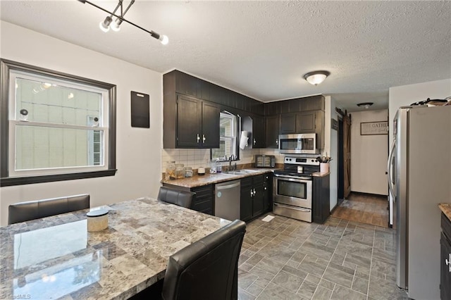 267 Pine Ridge Trl, Pinnacle, NC 27043 - kitchen with appliances with stainless steel finishes, tasteful backsplash, a textured ceiling, and light stone countertops