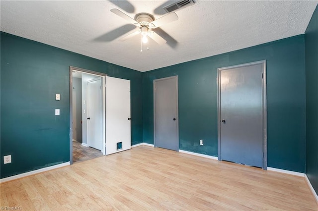 267 Pine Ridge Trl, Pinnacle, NC 27043 - unfurnished bedroom with wood finished floors, multiple closets, a textured ceiling, and a ceiling fan