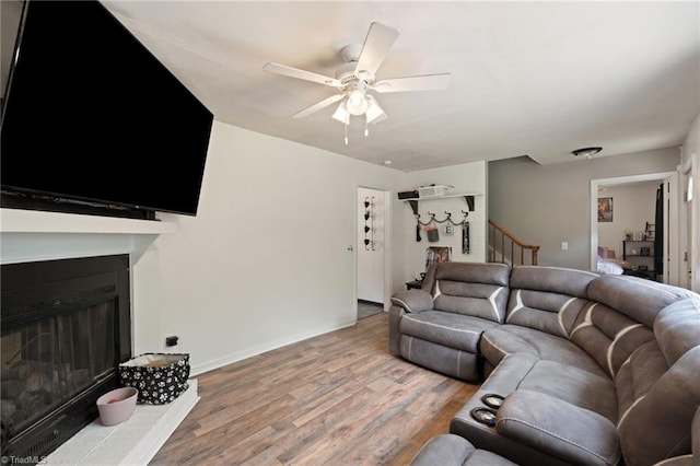 267 Pine Ridge Trl, Pinnacle, NC 27043 - living area featuring ceiling fan, wood finished floors, a fireplace with raised hearth, and stairs