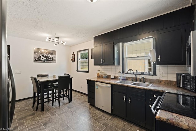 267 Pine Ridge Trl, Pinnacle, NC 27043 - kitchen with dishwasher, tasteful backsplash, a textured ceiling, dark cabinetry, and a chandelier