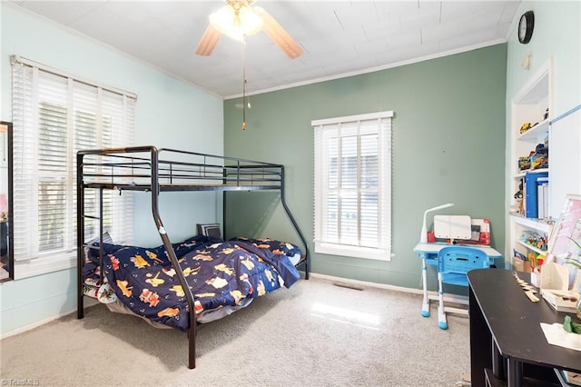 carpeted bedroom with a ceiling fan, baseboards, and ornamental molding