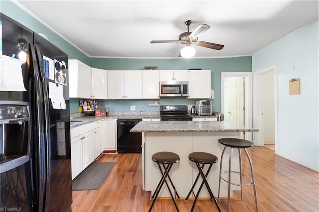 kitchen with black appliances, light wood-style flooring, and crown molding