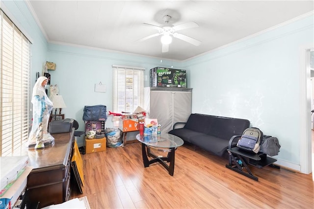 living area featuring a ceiling fan, wood finished floors, and ornamental molding